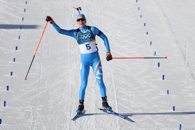 Italy's Lisa Vittozzi celebrates while crossing the finish line during the women's biathlon 10km pursuit event during the Milano Cortina 2026 Winter Olympic Games at the Anterselva Biathlon Arena (Sudtirol Arena) in Anterselva (Val Pusteria) on February 15, 2026. (Photo by Odd ANDERSEN / AFP)
