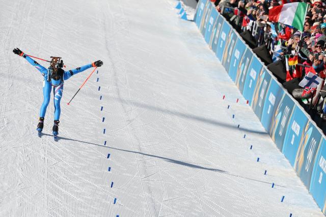 Italy's Lisa Vittozzi celebrates while crossing the finish line during the women's biathlon 10km pursuit event during the Milano Cortina 2026 Winter Olympic Games at the Anterselva Biathlon Arena (Sudtirol Arena) in Anterselva (Val Pusteria) on February 15, 2026. (Photo by Odd ANDERSEN / AFP)