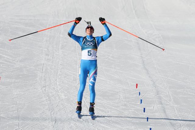 Italy's Lisa Vittozzi celebrates while crossing the finish line during the women's biathlon 10km pursuit event during the Milano Cortina 2026 Winter Olympic Games at the Anterselva Biathlon Arena (Sudtirol Arena) in Anterselva (Val Pusteria) on February 15, 2026. (Photo by Odd ANDERSEN / AFP)