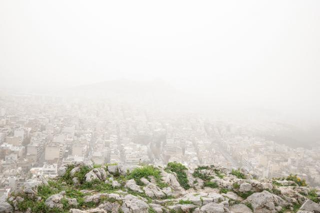 This photograph shows the city of Athens seen from the hill of Tourkovounia, as southerly winds carry waves of Saharan dust, in Athens, on February 15, 2026. (Photo by Angelos TZORTZINIS / AFP)