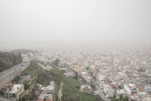 This photograph shows the city of Athens seen from the hill of Tourkovounia, as southerly winds carry waves of Saharan dust, in Athens, on February 15, 2026. (Photo by Angelos TZORTZINIS / AFP)