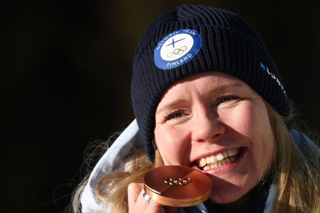 Bronze medallist Finland's Suvi Minkkinen poses on the podium of the women's biathlon 10km pursuit event during the Milano Cortina 2026 Winter Olympic Games at the Anterselva Biathlon Arena (Sudtirol Arena) in Anterselva (Val Pusteria) on February 15, 2026. (Photo by FRANCK FIFE / AFP)