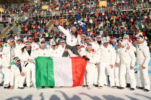 Gold medallist Italy's Lisa Vittozzi (above) poses with her teammates after the victory ceremony of the women's biathlon 10km pursuit event during the Milano Cortina 2026 Winter Olympic Games at the Anterselva Biathlon Arena (Sudtirol Arena) in Anterselva (Val Pusteria) on February 15, 2026. (Photo by Odd ANDERSEN / AFP)