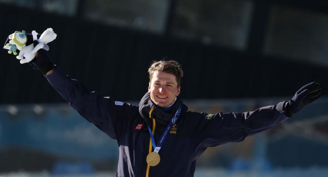 Gold medallist Sweden's Martin Ponsiluoma poses on the podium of the men's biathlon 12,5km pursuit event during the Milano Cortina 2026 Winter Olympic Games at the Anterselva Biathlon Arena (Sudtirol Arena) in Anterselva (Val Pusteria) on February 15, 2026. (Photo by Odd ANDERSEN / AFP)