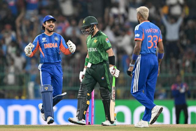 Pakistan's Sahibzada Farhan (C) walks back to the pavilion after his dismissal by India's Hardik Pandya (R) during the 2026 ICC Men's T20 Cricket World Cup group stage match between India and Pakistan at the R Premadasa Stadium in Colombo on February 15, 2026. (Photo by Ishara S.KODIKARA / AFP)