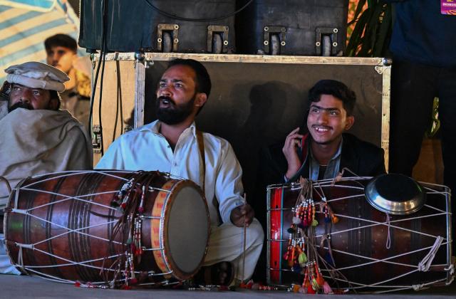Cricket fans watch the 2026 ICC Men's T20 Cricket World Cup group stage match between India and Pakistan streaming live from Colombo, in Islamabad on February 15, 2026. (Photo by Aamir QURESHI / AFP)