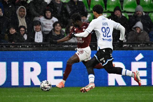 Metz's Ivorian defender #39 Koffi Kouao (L) fights for the ball with Auxerre's French-Ivorian defender #92 Clement Akpa (R) during the French L1 football match between FC Metz and AJ Auxerre at Stade Saint-Symphorien in Longeville-les-Metz, northeastern France, on February 15, 2026. (Photo by Jean-Christophe VERHAEGEN / AFP)