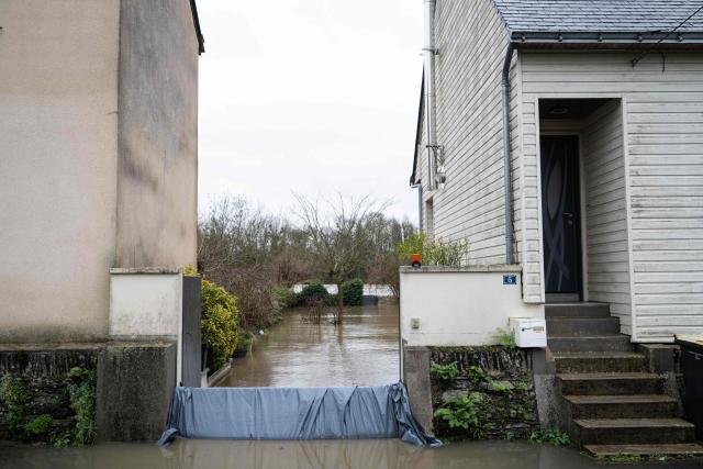 This photograph shows a flooded house in Pont de Ce, western France, on February 15, 2026. The prefecture of Maine-et-Loire issued an evacuation order on the evening of February 14, 2026 evening for several municipalities near Angers which were deemed to be at risk of being isolated by floods and flooded roads. (Photo by Sebastien Salom-Gomis / AFP)