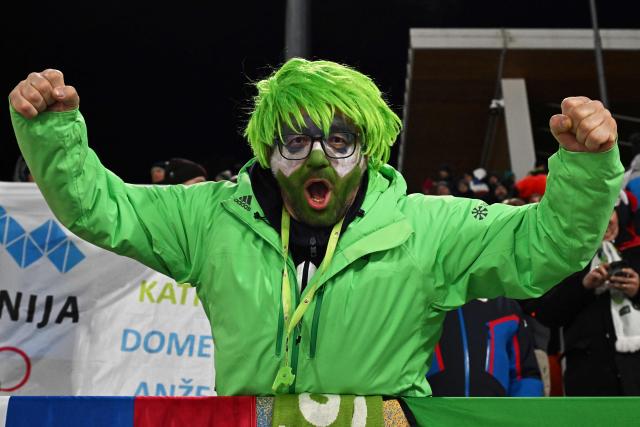 A fan of Slovenia cheers during the trial round of the women's large hill individual ski jumping of the Milano Cortina 2026 Winter Olympic Games at Predazzo Ski Jumping Stadium in Predazzo (Val di Fiemme), on February 15, 2026. (Photo by Javier SORIANO / AFP)