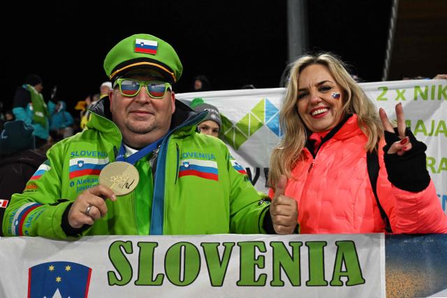 Fans of Slovenia cheer during the trial round of the women's large hill individual ski jumping of the Milano Cortina 2026 Winter Olympic Games at Predazzo Ski Jumping Stadium in Predazzo (Val di Fiemme), on February 15, 2026. (Photo by Javier SORIANO / AFP)