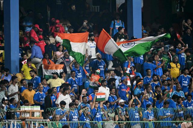 Fans wave India's national flag as they cheer from the stands during the 2026 ICC Men's T20 Cricket World Cup group stage match between India and Pakistan at the R Premadasa Stadium in Colombo on February 15, 2026. (Photo by Ishara S. KODIKARA / AFP)