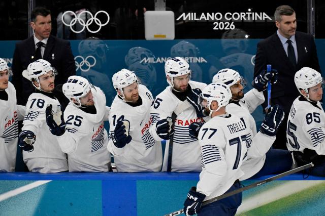 France's #77 Sacha Treille celebrates with teammates after scoring his team's second goal during the men's preliminary round Group A Ice Hockey match between Canada and France at the Milano Santagiulia Ice Hockey Arena during the Milano Cortina 2026 Winter Olympic Games in Milan, on February 15, 2026. (Photo by Alexander NEMENOV / AFP)