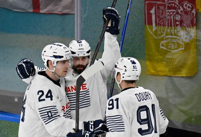 France's #77 Sacha Treille (C) celebrates with teammates after scoring his team's second goal during the men's preliminary round Group A Ice Hockey match between Canada and France at the Milano Santagiulia Ice Hockey Arena during the Milano Cortina 2026 Winter Olympic Games in Milan, on February 15, 2026. (Photo by Alexander NEMENOV / AFP)