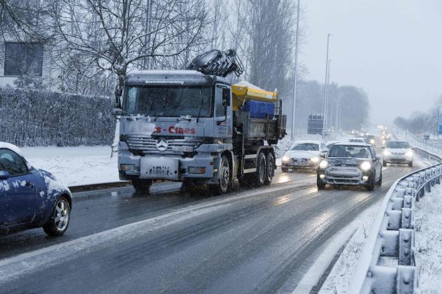 Motorists drive during heavy snowfall in Aalst on February 15, 2026. (Photo by NICOLAS MAETERLINCK / Belga / AFP) / Belgium OUT