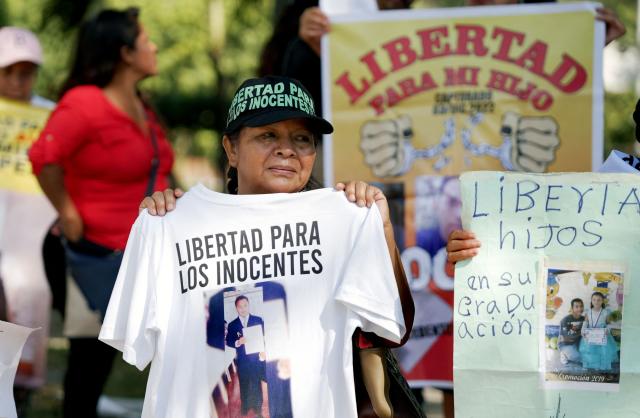 Salvadoran activists hold signs demanding the release of their loved ones during a protest against mass trials under the emergency regime which allows arrests without a warrant, in San Salvador, on February 15, 2026. (Photo by Marvin RECINOS / AFP)