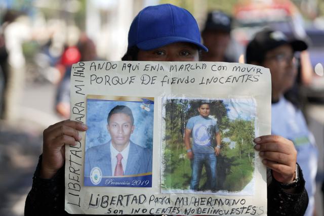 An activist holds a poster demanding the release of her loved ones during a protest against mass trials under the emergency regime which allows arrests without a warrant, in San Salvador, on February 15, 2026. (Photo by Marvin RECINOS / AFP)