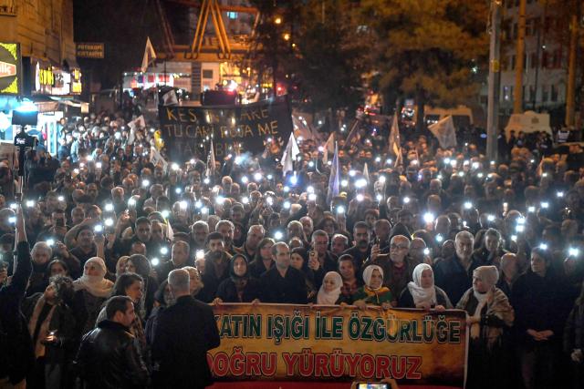 Members of the Kurdish community hold a banner reading "We are walking towards freedom with the light of truth" as they take part in a protest calling for the release of convicted Kurdistan Worker's Party (PKK) leader Abdullah Ocalan in Diyarbakir on February 15, 2026. Ocalan was captured by Turkish secret agents in Kenya in 1999, brought to Turkey and sentenced to death. His sentence was later commuted to life imprisonment. (Photo by Ilyas AKENGIN / AFP)