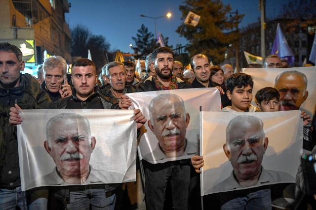 Members of the Kurdish community hold portraits during a protest calling for the release of convicted Kurdistan Worker's Party (PKK) leader Abdullah Ocalan in Diyarbakir on February 15, 2026. Ocalan was captured by Turkish secret agents in Kenya in 1999, brought to Turkey and sentenced to death. His sentence was later commuted to life imprisonment. (Photo by Ilyas AKENGIN / AFP)