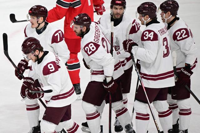 Latvia's #77 Kristaps Roberts Zile celebrates after scoring his team's first goal during the men's preliminary round Group C Ice Hockey match between Denmark and Latvia at the Milano Rho Ice Hockey Arena during the Milano Cortina 2026 Winter Olympic Games in Milan, on February 15, 2026. (Photo by Piero CRUCIATTI / AFP)