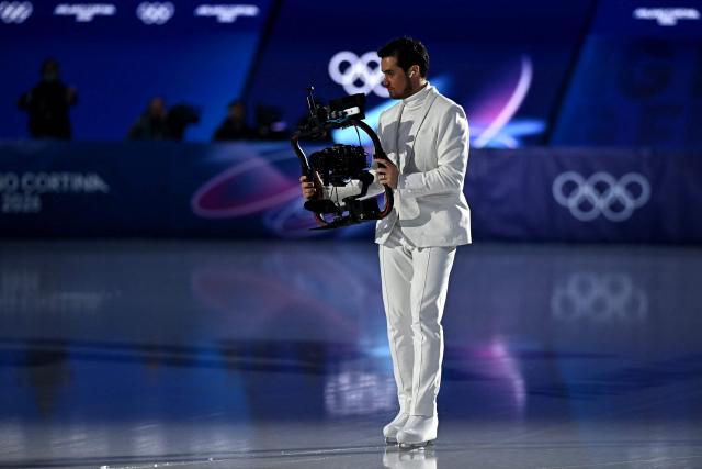 A man handles a camera ahead of the figure skating pair skating short program during the Milano Cortina 2026 Winter Olympic Games at Milano Ice Skating Arena in Milan on February 15, 2026. (Photo by Gabriel BOUYS / AFP)