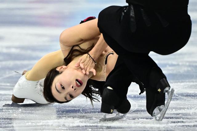 China's Han Cong and China's Sui Wenjing compete in the figure skating pair skating short program during the Milano Cortina 2026 Winter Olympic Games at Milano Ice Skating Arena in Milan on February 15, 2026. (Photo by JULIEN DE ROSA / AFP)