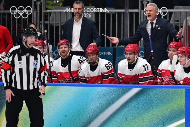 Denmark's Swedish coach Mikael Gath (back R) gestures towards the referee during the men's preliminary round Group C Ice Hockey match between Denmark and Latvia at the Milano Rho Ice Hockey Arena during the Milano Cortina 2026 Winter Olympic Games in Milan, on February 15, 2026. (Photo by Piero CRUCIATTI / AFP)