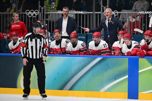 Denmark's Swedish coach Mikael Gath (back R) gestures towards the referee during the men's preliminary round Group C Ice Hockey match between Denmark and Latvia at the Milano Rho Ice Hockey Arena during the Milano Cortina 2026 Winter Olympic Games in Milan, on February 15, 2026. (Photo by Piero CRUCIATTI / AFP)