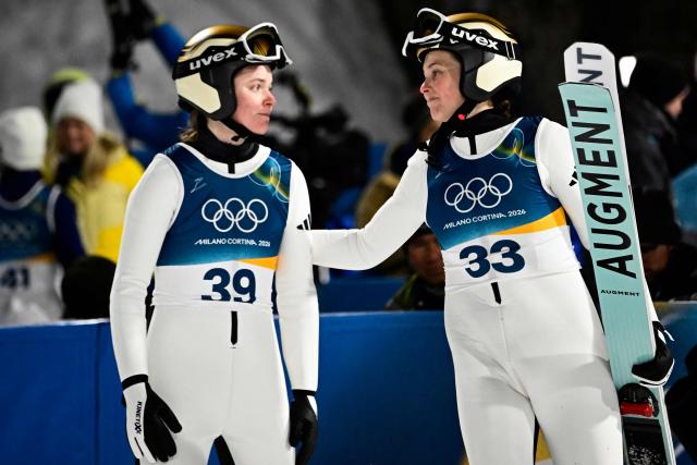 Norway's Eirin Maria Kvandal (L) and Norway's Silje Opseth react after jumping during the final round of the women's large hill individual ski jumping of the Milano Cortina 2026 Winter Olympic Games at Predazzo Ski Jumping Stadium in Predazzo (Val di Fiemme), on February 15, 2026. (Photo by Tobias SCHWARZ / AFP)
