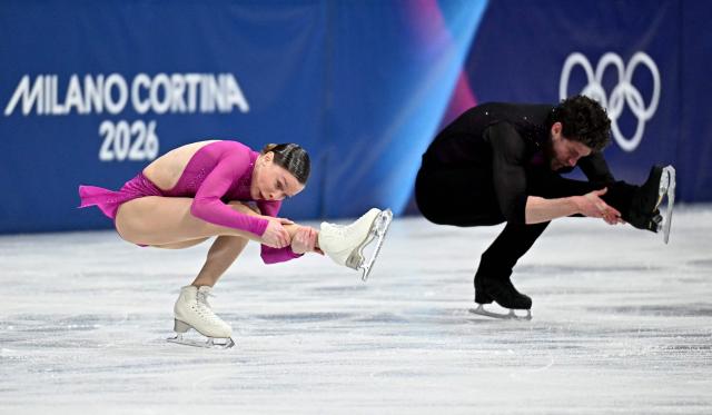 Poland's Michal Wozniak and Poland's Ioulia Chtchetinina compete in the figure skating pair skating short program during the Milano Cortina 2026 Winter Olympic Games at Milano Ice Skating Arena in Milan on February 15, 2026. (Photo by Gabriel BOUYS / AFP)