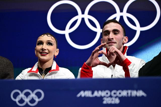 Georgia's Anastasiia Metelkina and Georgia's Luka Berulava react in the kiss and cry area after competing in the figure skating pair skating short program during the Milano Cortina 2026 Winter Olympic Games at Milano Ice Skating Arena in Milan on February 15, 2026. (Photo by JULIEN DE ROSA / AFP)