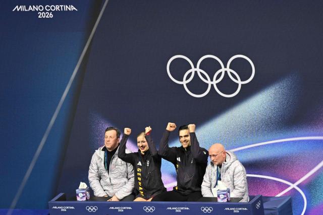 Germany's Minerva Fabienne Hase (2nd L) and Germany's Nikita Volodin (2nd R) react in the kiss and cry area after competing in the figure skating pair skating short program during the Milano Cortina 2026 Winter Olympic Games at Milano Ice Skating Arena in Milan on February 15, 2026. (Photo by Antonin THUILLIER / AFP)