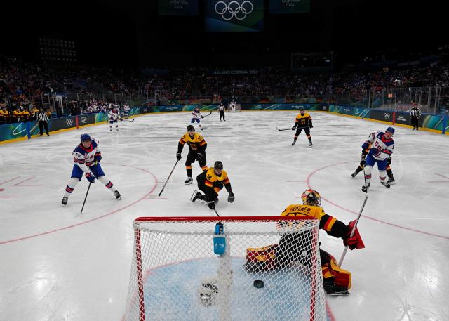 Germany's #37 Maximilian Franzreb (front) deflects the puck during the men's preliminary round Group C Ice Hockey match between USA and Germany at the Milano Santagiulia Ice Hockey Arena during the Milano Cortina 2026 Winter Olympic Games in Milan, on February 15, 2026. (Photo by Alexander NEMENOV / POOL / AFP)