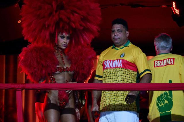 Brazilian former football player Ronaldo and Brazilian television presenter Sabrina Sato are seen above a float of the Academicos de Niteroi samba school before the opening night of the Rio Carnival at the Marques de Sapucai Sambadrome in Rio de Janeiro, Brazil, on February 15, 2026. (Photo by Pablo PORCIUNCULA / AFP)