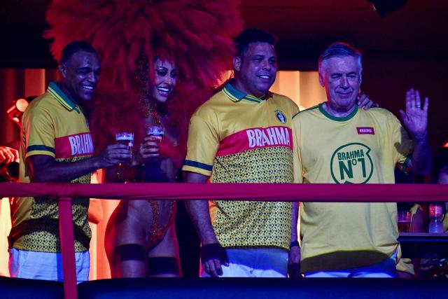Brazil's Italian national football team coach Carlo Ancelotti (R), waves next to former football players Ronaldo (C-R), Brazilian television presenter Sabrina Sato and Denilson above a float of the Academicos de Niteroi samba school before the opening night of the Rio Carnival at the Marques de Sapucai Sambadrome in Rio de Janeiro, Brazil, on February 15, 2026. (Photo by Pablo PORCIUNCULA / AFP)