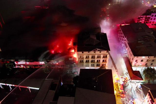 (FILES) This aerial view shows firefighters working to extinguish a fire in an apartment tower in the central area of the bay of Guayaquil, Ecuador, on February 11, 2026. On February 15, 2026, the Ecuadorian government said that a wave of large fires that broke out this week in Guayaquil, one of the scenes of bloody disputes between drug gangs, was intentional in order to generate ‘violence and disorder.’ (Photo by Marcos PIN / AFP)