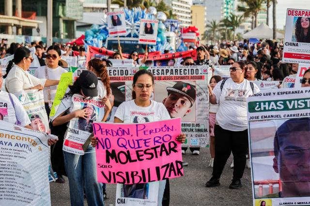Members of a group of "searching mothers" hold portraits of missing persons during the parade of International Carnival in Mazatlan, Sinaloa State, Mexico, on February 15, 2026. (Photo by Jesus Verdugo / AFP)