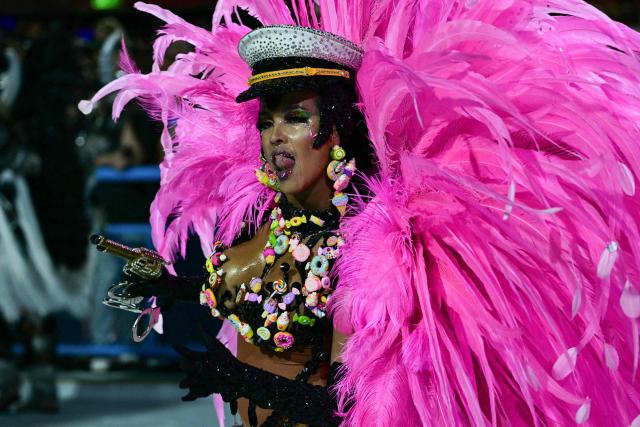 A reveller of the Imperatriz Leopoldinense samba school performs during the opening night of the Rio Carnival at the Marques de Sapucai Sambadrome in Rio de Janeiro, Brazil, on February 16, 2026. (Photo by Pablo PORCIUNCULA / AFP)