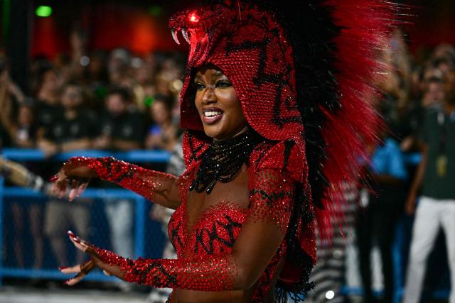 A reveller of the Imperatriz Leopoldinense samba school performs during the opening night of the Rio Carnival at the Marques de Sapucai Sambadrome in Rio de Janeiro, Brazil, on February 16, 2026. (Photo by Pablo PORCIUNCULA / AFP)