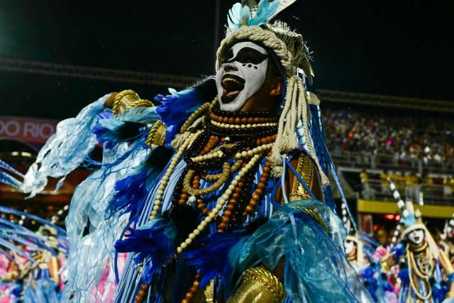 A reveller of the Imperatriz Leopoldinense samba school performs during the opening night of the Rio Carnival at the Marques de Sapucai Sambadrome in Rio de Janeiro, Brazil, on February 16, 2026. (Photo by Pablo PORCIUNCULA / AFP)