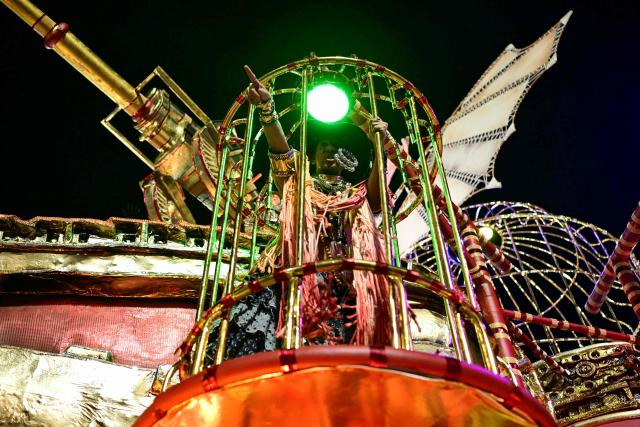 A reveller of the Imperatriz Leopoldinense samba school performs during the opening night of the Rio Carnival at the Marques de Sapucai Sambadrome in Rio de Janeiro, Brazil, on February 16, 2026. (Photo by Pablo PORCIUNCULA / AFP)