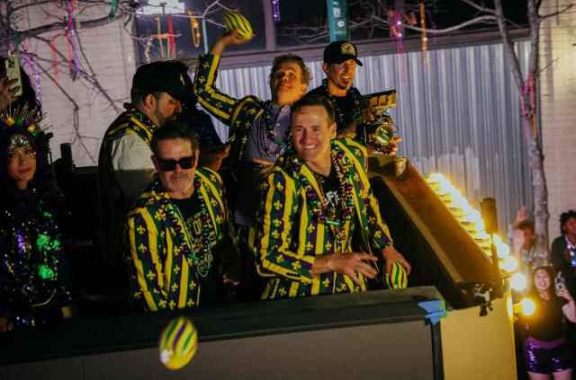 Former New Orleans Saints quarterback Drew Brees (C) grand marshalls the Krewe of Bacchus as it rolls down St. Charles Avenue during Mardi Gras festivities in New Orleans, Louisiana, on February 15, 2026. (Photo by Sandy HUFFAKER / AFP)