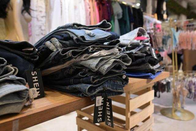 Imported clothes from Chinese brand Shein are for sale in a store in Buenos Aires on February 6, 2026. The textile industry in Argentina is going through a crisis with falling sales, rising local production costs, and concerns about competition from imports. Since 2023, the textile sector has laid off more than 18,000 people and is operating at one-third of its installed capacity, according to February data from the consulting firm Analytica and the Argentine Textile Industries Federation (FITA). (Photo by JUAN MABROMATA / AFP)