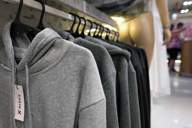 Imported clothes from Chinese brand Shein are for sale in a store in Buenos Aires on February 6, 2026. The textile industry in Argentina is going through a crisis with falling sales, rising local production costs, and concerns about competition from imports. Since 2023, the textile sector has laid off more than 18,000 people and is operating at one-third of its installed capacity, according to February data from the consulting firm Analytica and the Argentine Textile Industries Federation (FITA). (Photo by JUAN MABROMATA / AFP)