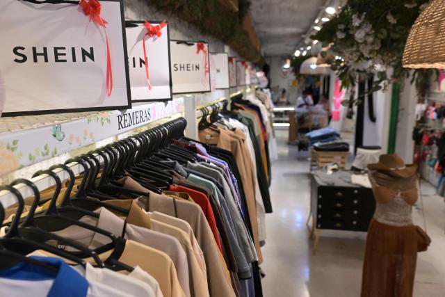 Imported clothes from Chinese brand Shein are for sale in a store in Buenos Aires on February 6, 2026. The textile industry in Argentina is going through a crisis with falling sales, rising local production costs, and concerns about competition from imports. Since 2023, the textile sector has laid off more than 18,000 people and is operating at one-third of its installed capacity, according to February data from the consulting firm Analytica and the Argentine Textile Industries Federation (FITA). (Photo by JUAN MABROMATA / AFP)