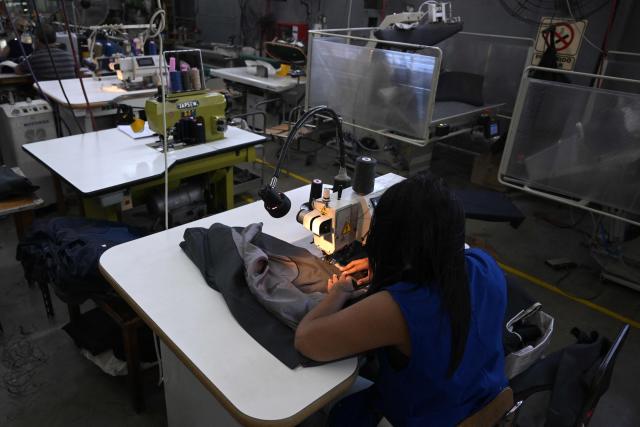 Workers make suites jackets at Argentine formal wear factory "Confecciones Seman S.A." in Buenos Aires on February 10, 2026. The textile industry in Argentina is going through a crisis with falling sales, rising local production costs, and concerns about competition from imports. Since 2023, the textile sector has laid off more than 18,000 people and is operating at one-third of its installed capacity, according to February data from the consulting firm Analytica and the Argentine Textile Industries Federation (FITA). (Photo by JUAN MABROMATA / AFP)
