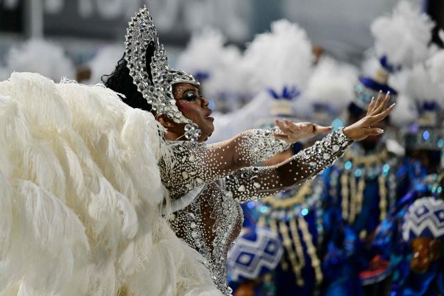 A reveller of the Portela samba school performs during the opening night of the Rio Carnival at the Marques de Sapucai Sambadrome in Rio de Janeiro, Brazil, on February 16, 2026. (Photo by Pablo PORCIUNCULA / AFP)