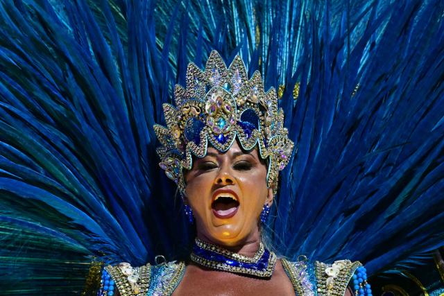 A reveller of the Portela samba school performs during the opening night of the Rio Carnival at the Marques de Sapucai Sambadrome in Rio de Janeiro, Brazil, on February 16, 2026. (Photo by Pablo PORCIUNCULA / AFP)