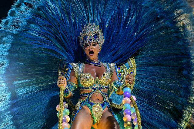 A reveller of the Portela samba school performs during the opening night of the Rio Carnival at the Marques de Sapucai Sambadrome in Rio de Janeiro, Brazil, on February 16, 2026. (Photo by Pablo PORCIUNCULA / AFP)