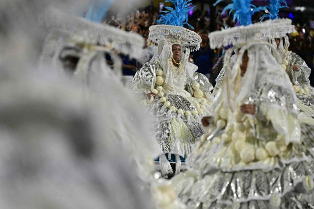 A reveller of the Portela samba school performs during the opening night of the Rio Carnival at the Marques de Sapucai Sambadrome in Rio de Janeiro, Brazil, on February 16, 2026. (Photo by Pablo PORCIUNCULA / AFP)