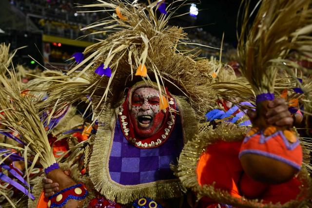 A reveller of the Portela samba school performs during the opening night of the Rio Carnival at the Marques de Sapucai Sambadrome in Rio de Janeiro, Brazil, on February 16, 2026. (Photo by Pablo PORCIUNCULA / AFP)